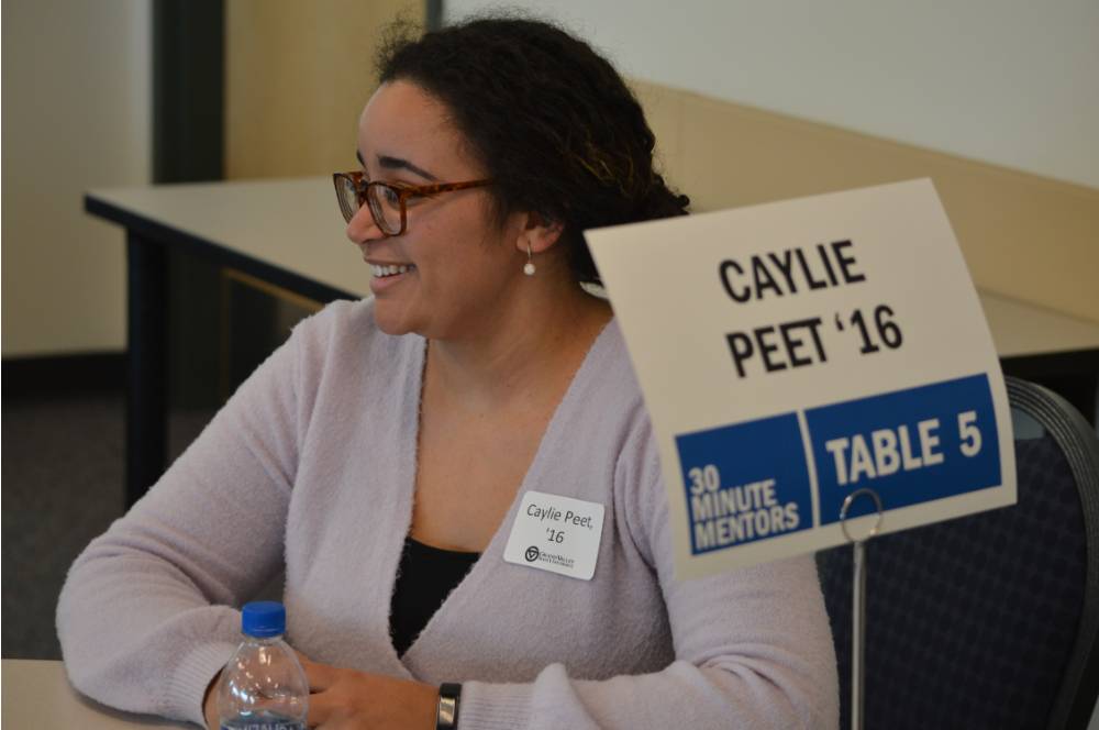 Caylie Peet smiling while talking with students at the 30 Minute Mentors Event
